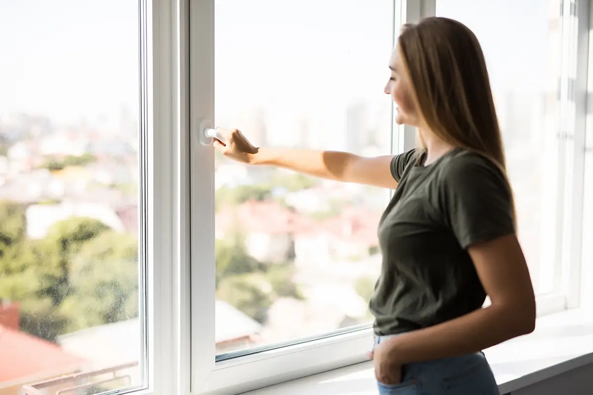 Homeowner opening a new double-glazed window in a Melbourne home